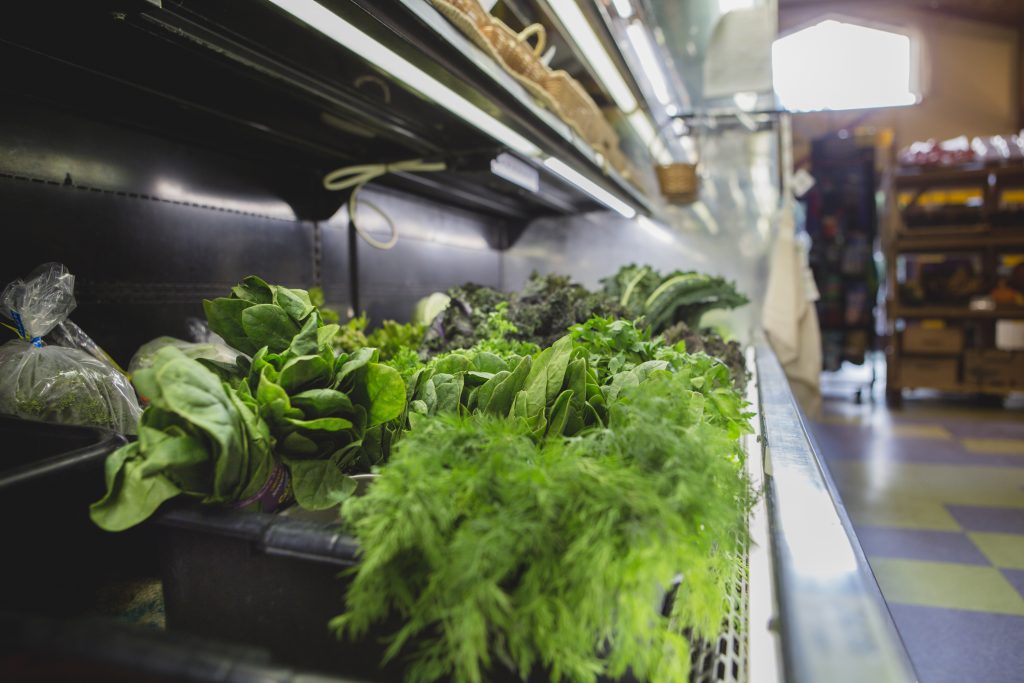 Bunches of fresh greens sit temptingly in the Cortes Co-op produce cooler.